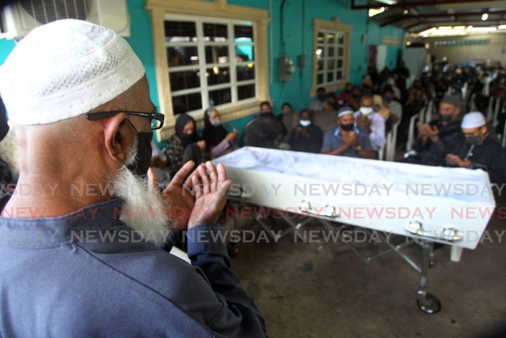 ALLAH, RECEIVE HIM: Muslims pray during the funeral for Ijaz Haniff on Friday at his home in Realize Road, Princes Town. PHOTO BY LINCOLN HOLDER - 