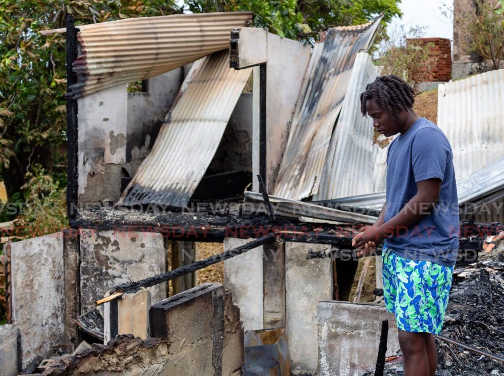 Jubari Phillips, 16, looks at the damage after a fire early Monday morning destroyed the house he lived in at George Street, Glamorgan, Tobago. - David Reid