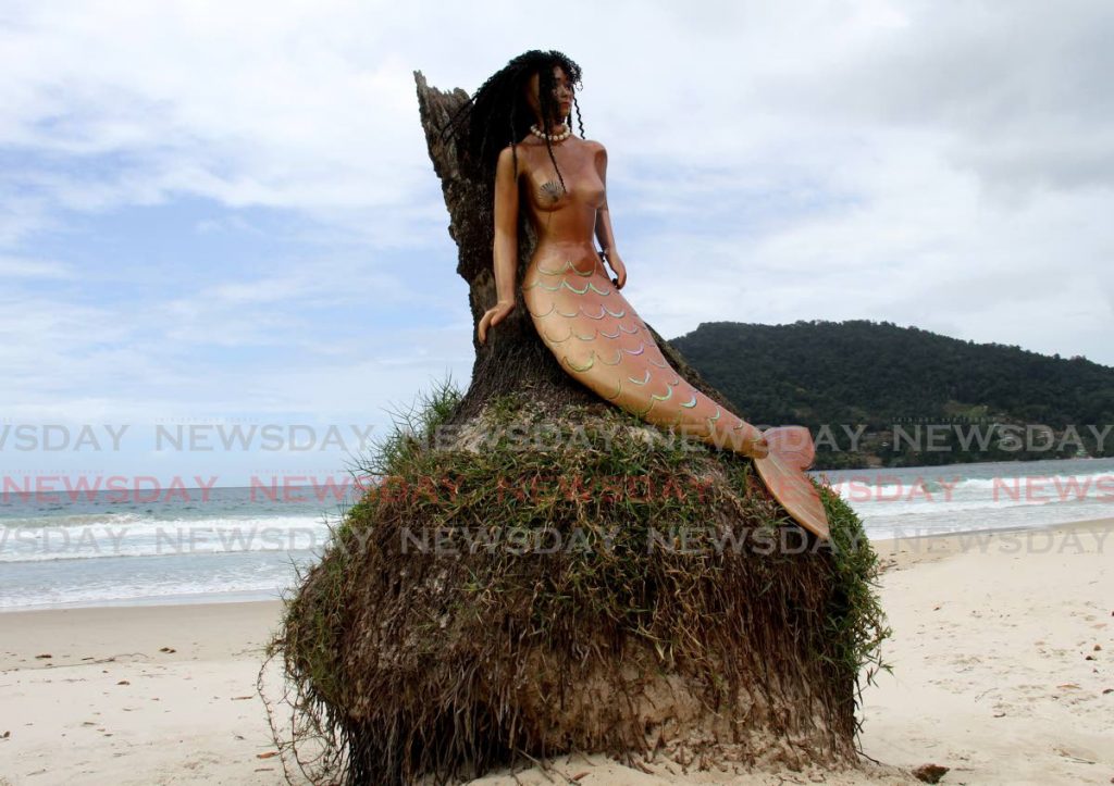 A mermaid rests on a coconut tree stump at Maracas Bay. - Photo by Ayanna Kinsale