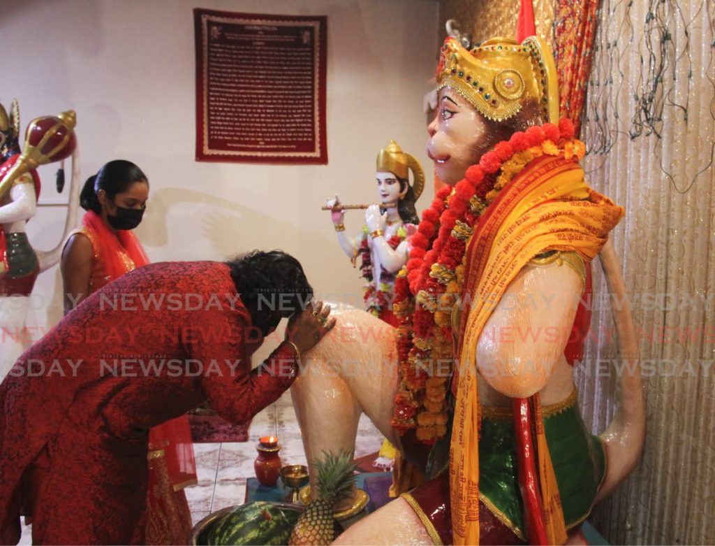 DEVOTION: Akeem Mohammed bows before a Lord Hanuman murti (statue) during Hanuman Jayanti worship on Monday evening at the SWAHA mandir in Madras Road, Cunupia. Photos by Ayanna Kinsale