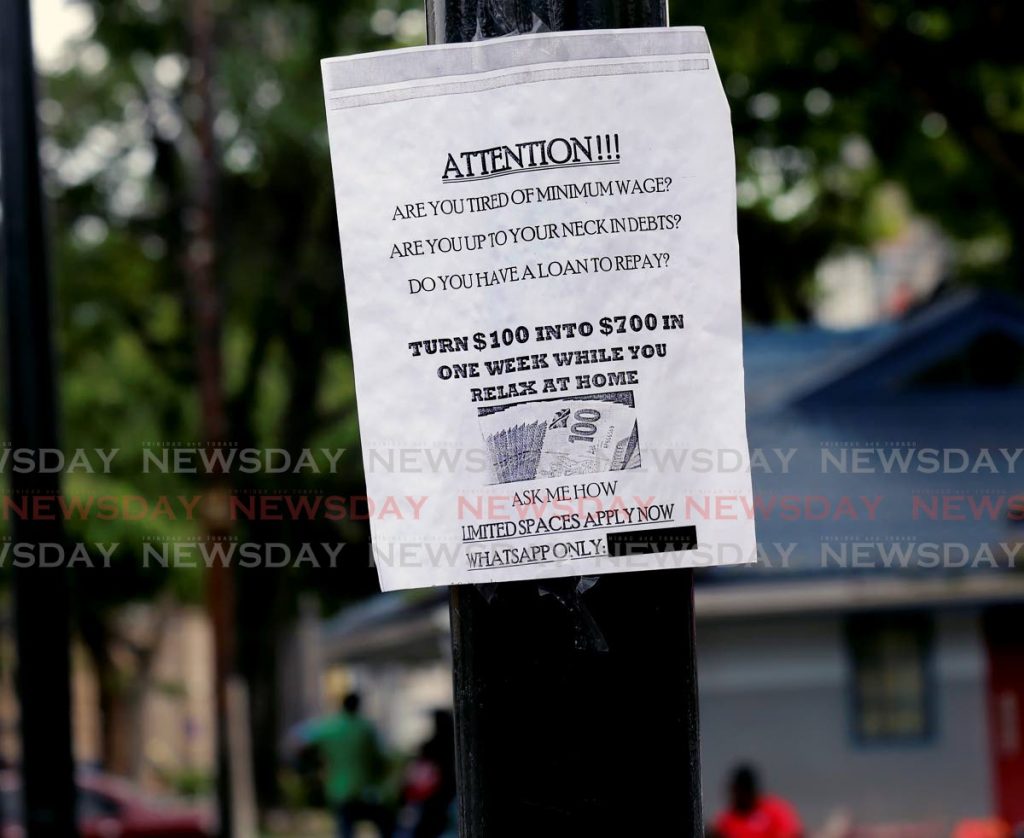 In this August 2020 file photo, a sign attached to a pole on the Brian Lara Promenade, Port of Spain, promises easy money while you relax at home. - SUREASH CHOLAI