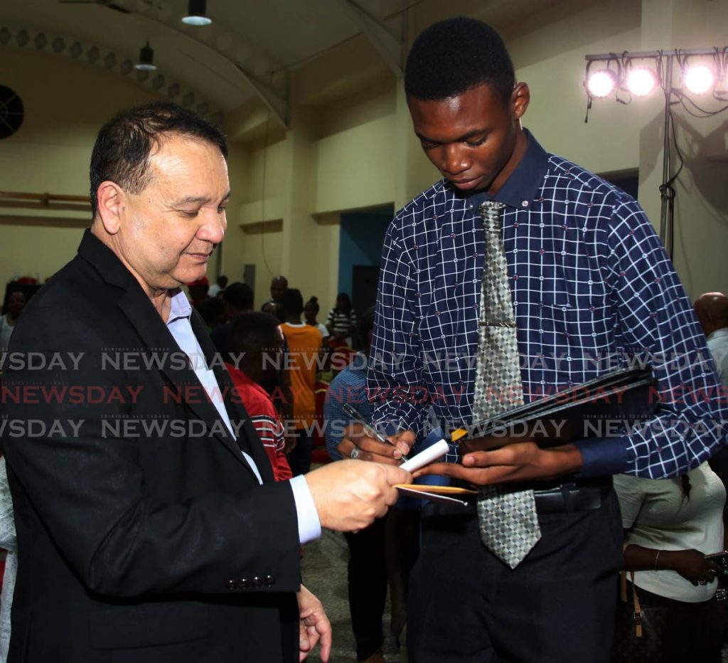 Energy Minister Franklin Khan accepts contact information from Kyle Pereira, a young man who made a passionate contribution at Conversations with the PM in Palo Seco on January 1, 2019. File photo - 