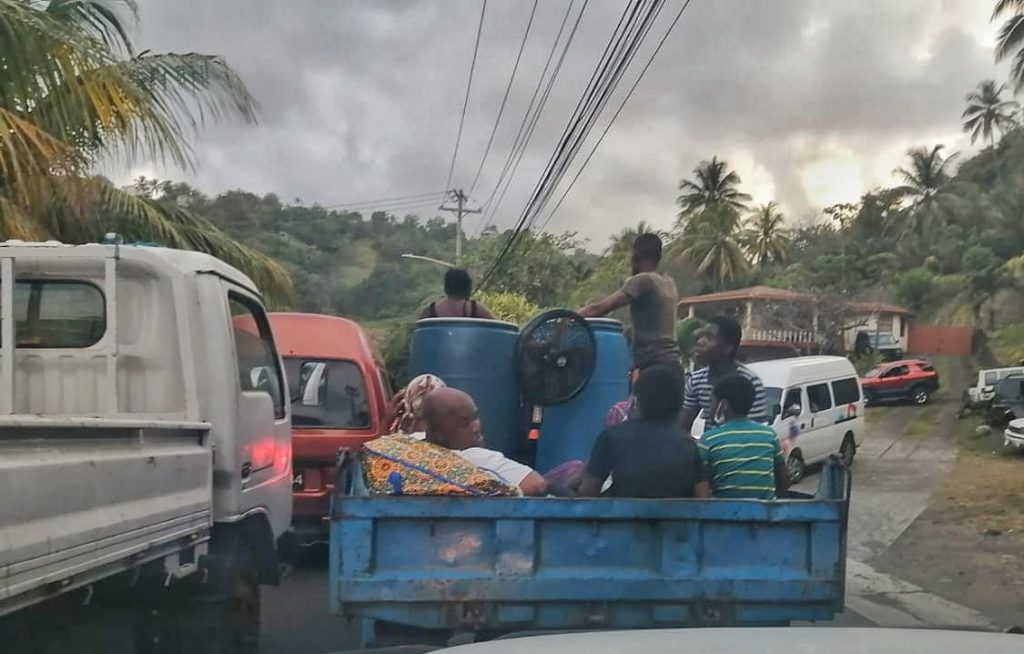 Residents of communities in northeast St Vincent, around the La Soufriere area, on trucks and at the side of the road waiting for rides to safer areas on Thursday evening. 
