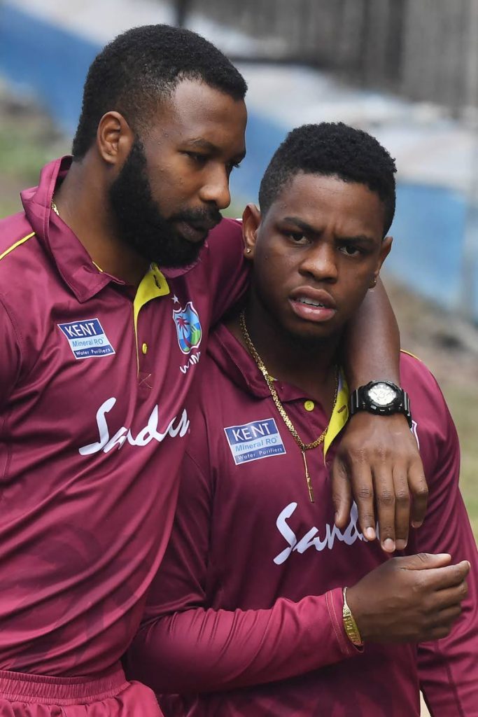 West Indies captain Kieron Pollard, left, puts his arm around Guyana's Shimron Hetmyer during a past training session.  (AFP PHOTO)