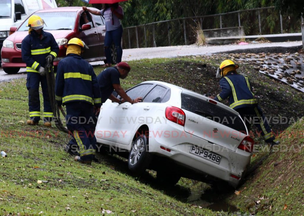 In this file photo, fire officers are seen assisting the driver of this car that ran off the road along the Uriah Butler Highway, Mt Hope. - SUREASH CHOLAI