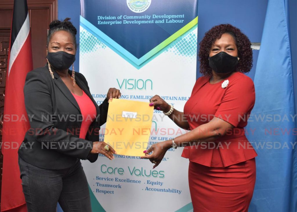 Secretary of Community Development, Enterprise Development and Labour Marslyn Melville-Jack, right, distributes a covid19 relief grant to a business owner at the Business Development Unit, Scarborough. Photo courtesy THA - 