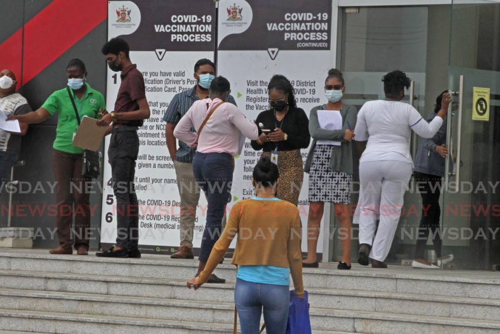 On Wednesday, people lined up outside the Southern Academy for the Performing Arts, San Fernando for Astrazeneca vaccine jabs. Photo by Marvin Hamilton