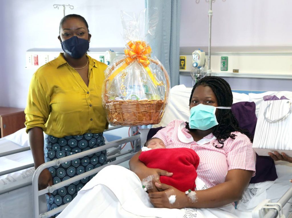 Health Secretary Tracy Davidson-Celestine, left, delivers a care package to new mother Charnelle Samuel who had a baby girl on Sunday at the Scarborough General Hospital. - THA