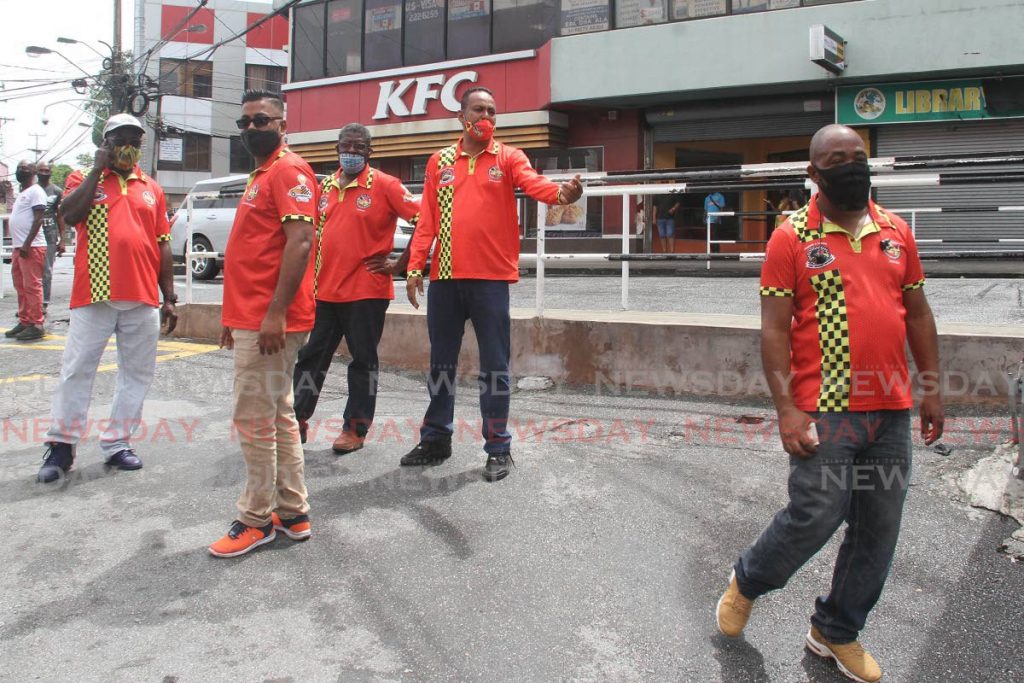 President of the La Romaine-Gulf City Taxi Driver's Association Reynold Dass, centre, along with other drivers, await passengers on Mucurapo Road, San Fernado on Monday. The association has implemented a temporary fare increase.  - Angelo Marcelle