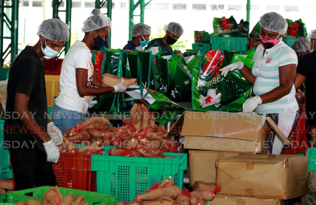 Workers at the Woodford Lodge packing warehouse in Chaguanas prepare fruits and vegetables for pandemic relief hampers being distributed to vulnerable families. - ROGER JACOB