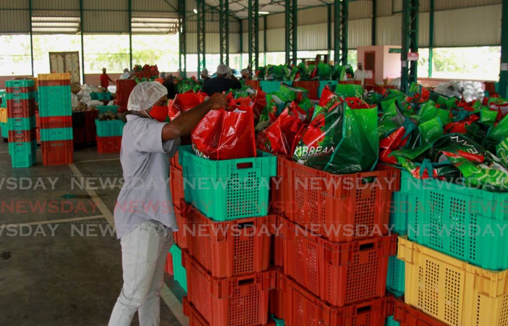  NAMDEVCO Director Rayber Bowen checks a food hamper at the  Woodford Lounge Packing Warehouse in Chaguanas. - ROGER JACOB
