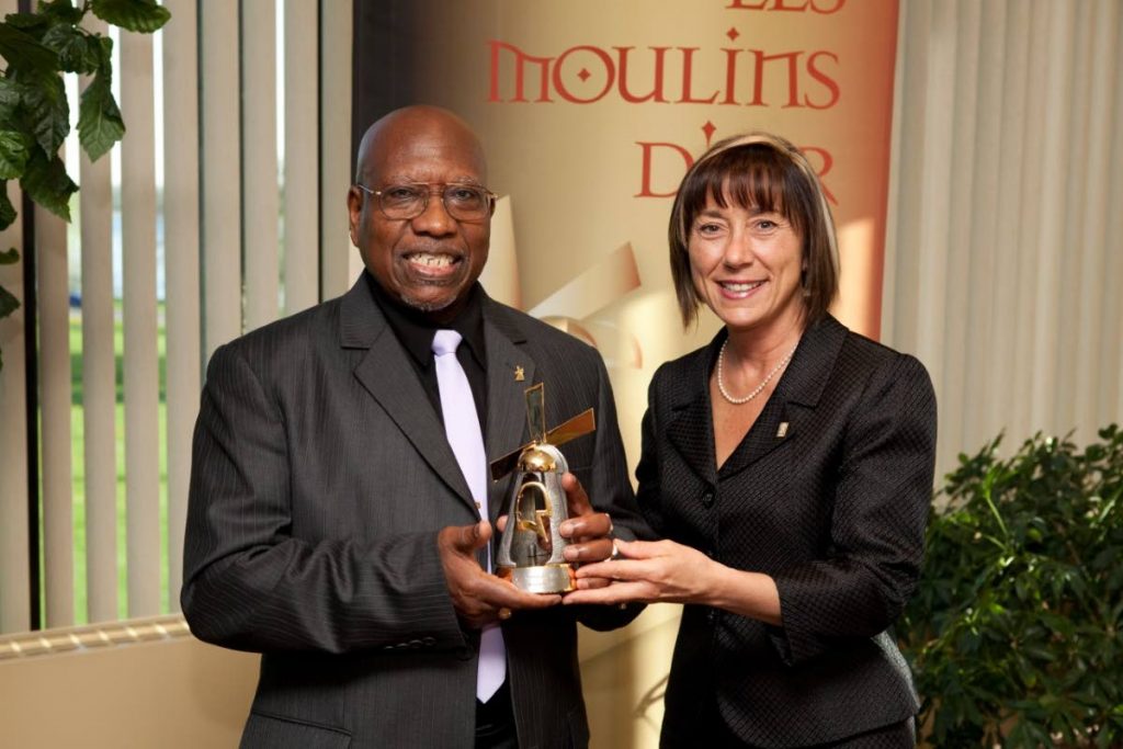 The Mayor of Lasalle, Manon Barbe, right, presents the The Moulin D'or The Golden Mill Award to Martin Albino in 2010 for the work he has done over the years in the community, including teaching youths and seniors the art of the pan. - 