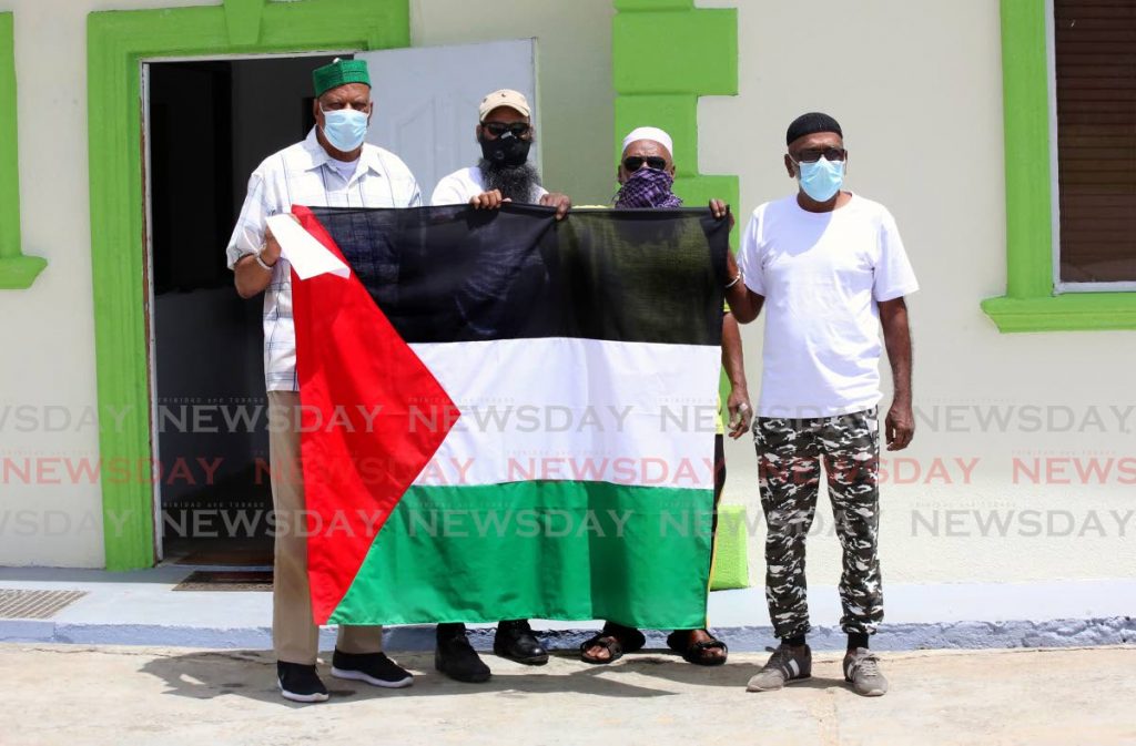 Jamaat al Muslimeen leader Yasin Abu Bakr (left) holding a Palestine flag with from left, Adul Abdullah, Hakim Alyesa and Lorris Ballack, outside the  Jamaat on  Mucurapo Road in Port of Spain.. - Photo by Sureash Cholai
