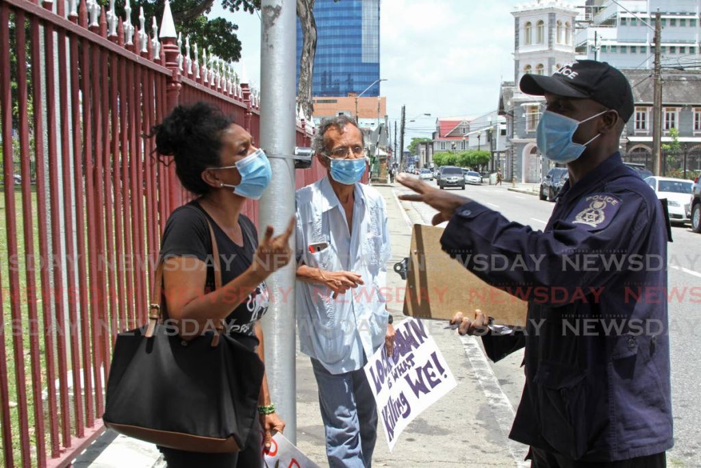 Marijuana activist Nazma Muller is confronted by police officers on St Vincent Street opposite the Parliament on Monday afternoon.  - Marvin Hamilton