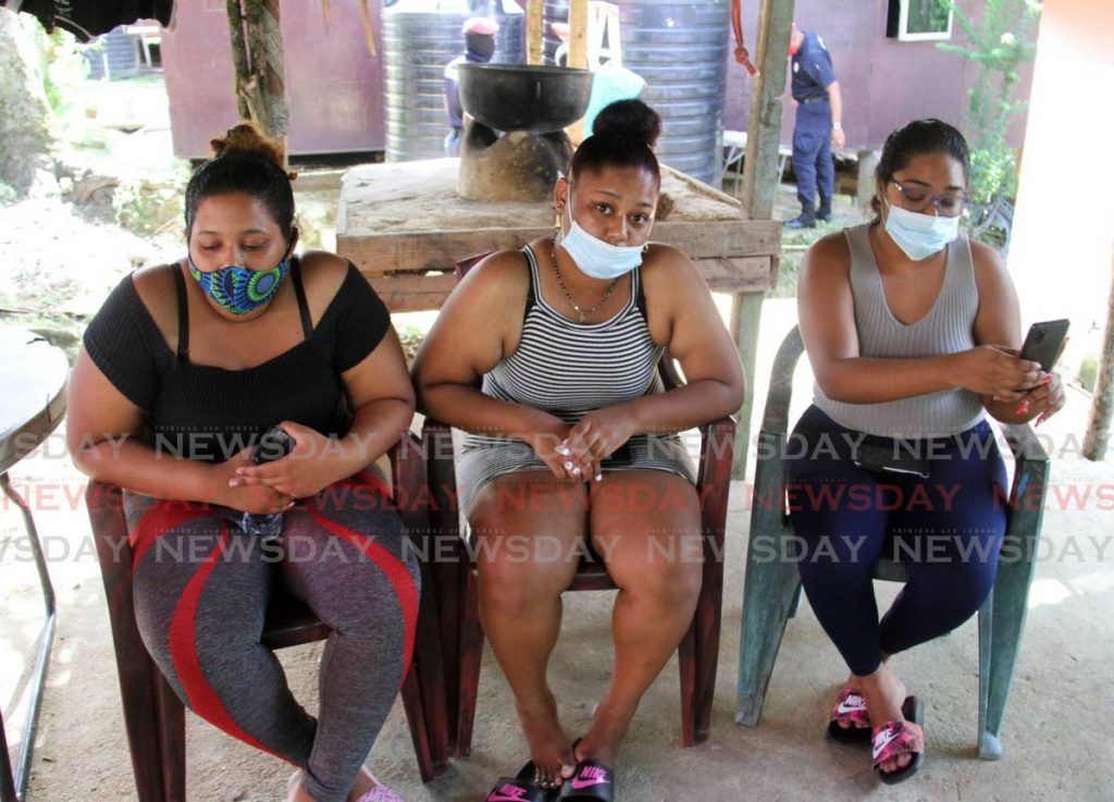 SORROWFUL TIME:
Sisters Priya Samuel, left, and Alicia Samuel, centre, with their cousin Kristin Diaz on Monday after the sisters’ mother Anna Maria Diaz was killed by Amar Zoongie at their Chaguanas home. Zoongie later ended his own life by drinking poison. - Angelo Marcelle