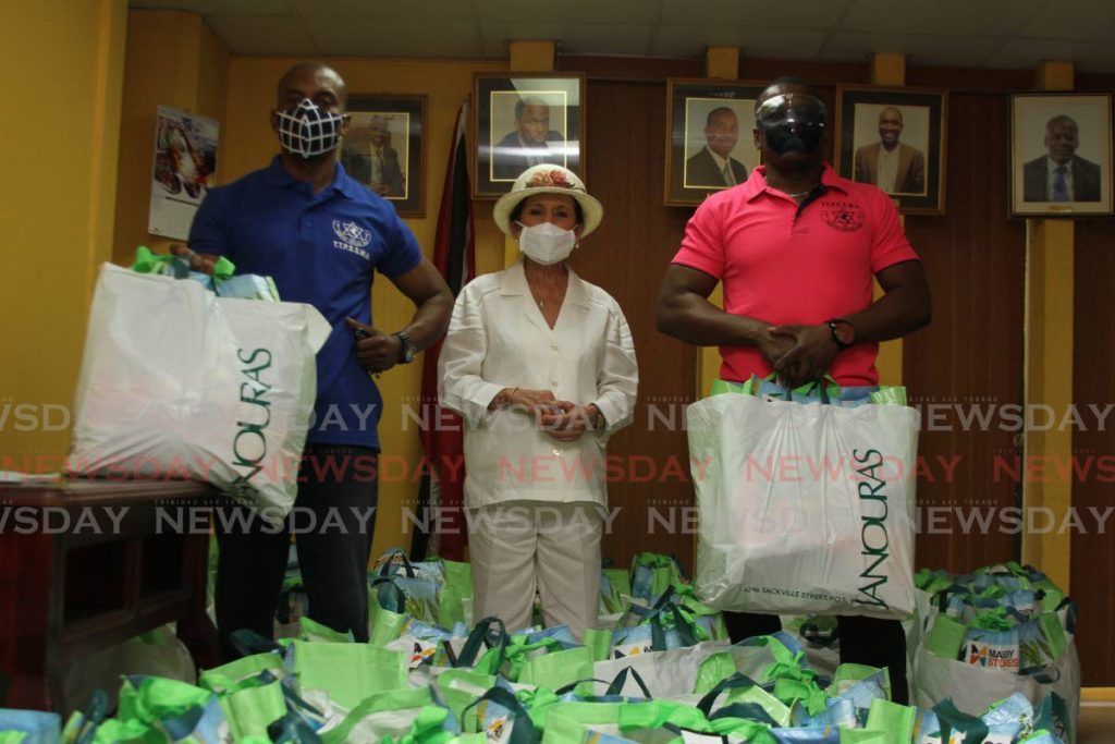 Hannah Janoura (middle) the owner of Janouras Custom Design Ltd donated hampers to TTPS officers who are infected with the covid19 virus on Corpus Christi morning, Insp Gideon Dickson (pink shirt) and Ancil Forde received on behalf of the officers. - Photo by Marvin Hamilton