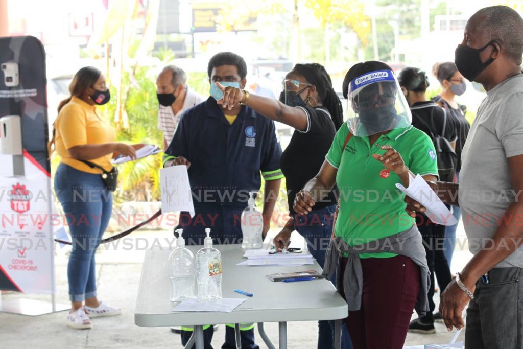 Workers employed with the manufacturing sector gather at the Divali Nagar site, Chaguanas last week during the rollout of the TT Manufacutrers Association vaccination drive. - Lincoln Holder