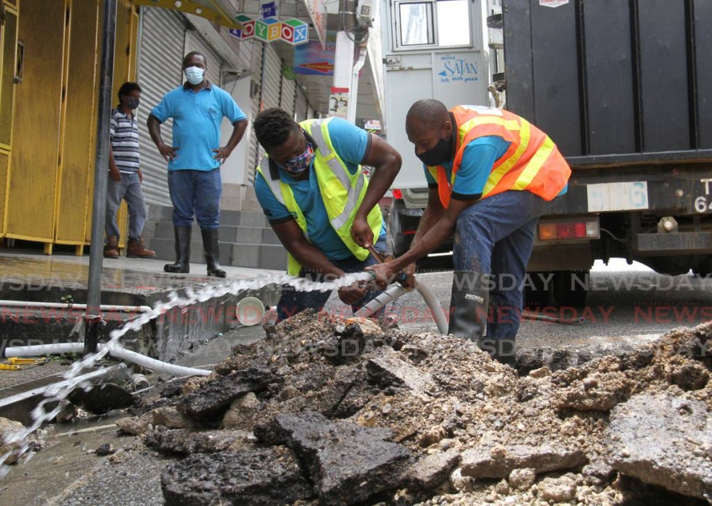 WASA workers repair a leaking pipe on High Street, San Fernando. - Photo by Ayanna Kinsale