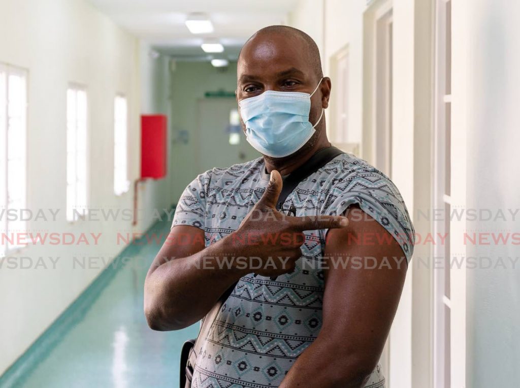 Tobagonian Dean Cipriani points to his arm after his second jab of the AstraZeneca vaccine at the Scarborough Health Centre, Tobago on Monday. PHOTO BY DAVID REID - 