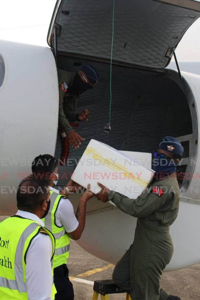 Members of the TT Air Guard unloading AstraZeneca vaccines donated to TT by Grenada and St Vincent and the Grenadines at the Piarco International Airport on Friday.  - Photo courtesy TT Air Guard