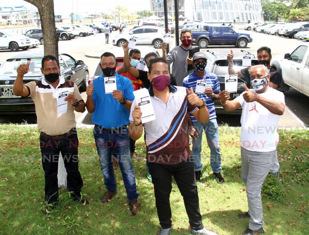 In this photo taken on June 12, workers of the construction sector display their vaccination cards after getting their first Sinopharm jab at SAPA, San Fernando. The workers say they’re happy they’re one step closer to getting back to work. - AYANNA KINSALE