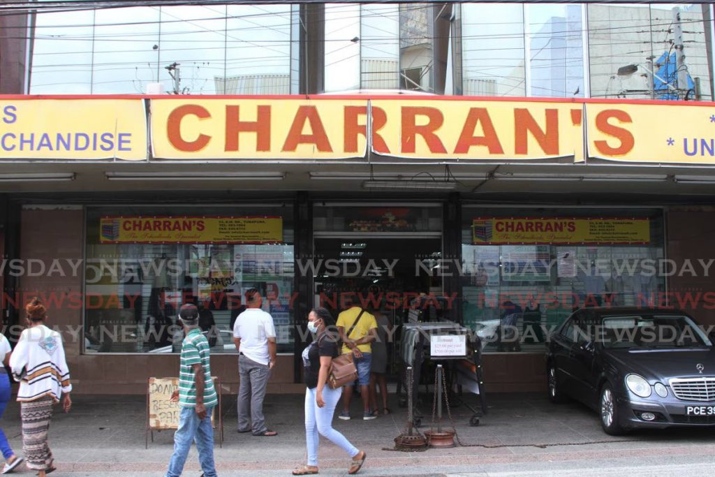 Customers wait to enter Charran's Bookstore in Tunapuna on Monday. - Marvin Hamilton