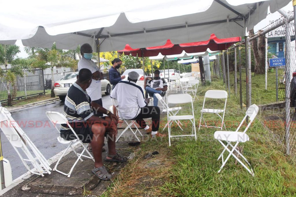 People wait under a tent outside the La Romaine Health Centre on Wedneday for their covid19 vaccines. Photo by Lincoln Holder - 