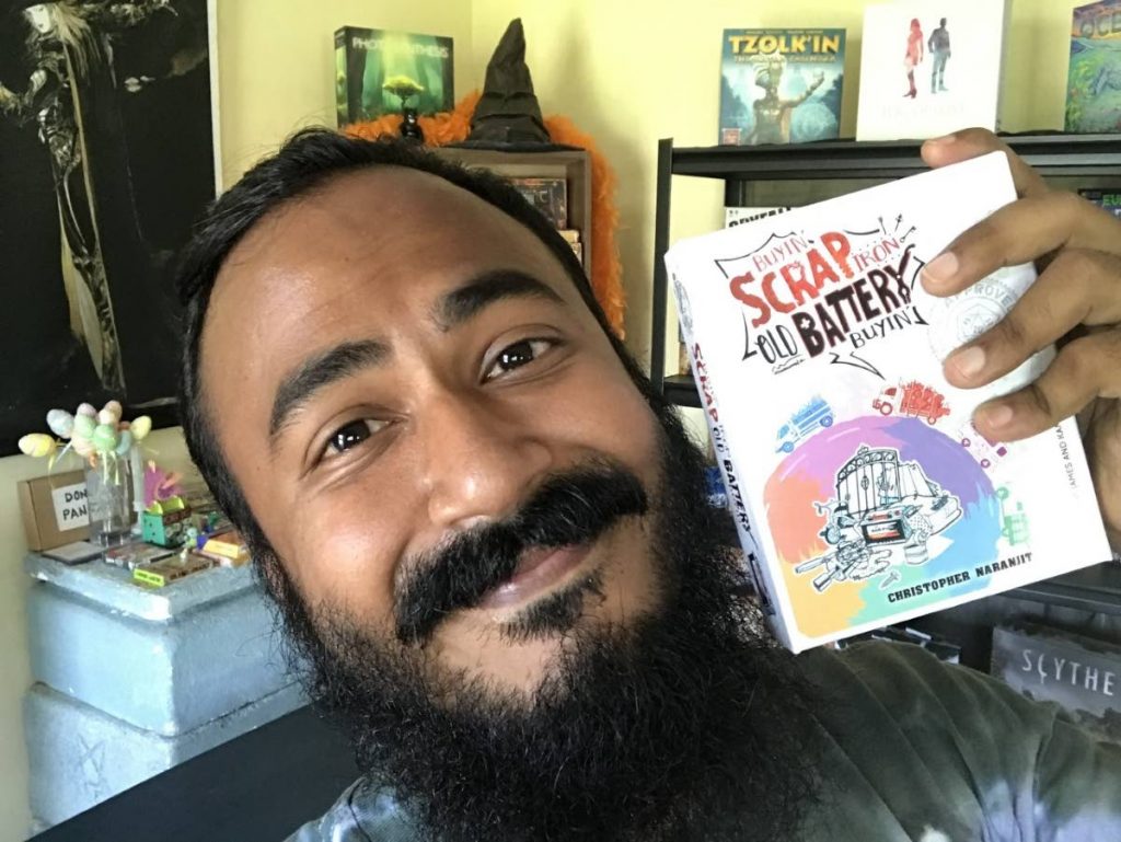 Christopher Naranjit, creator of Buyin' Scrap Iron; Old Battery Buyin' board game, with a copy of his game.   - 