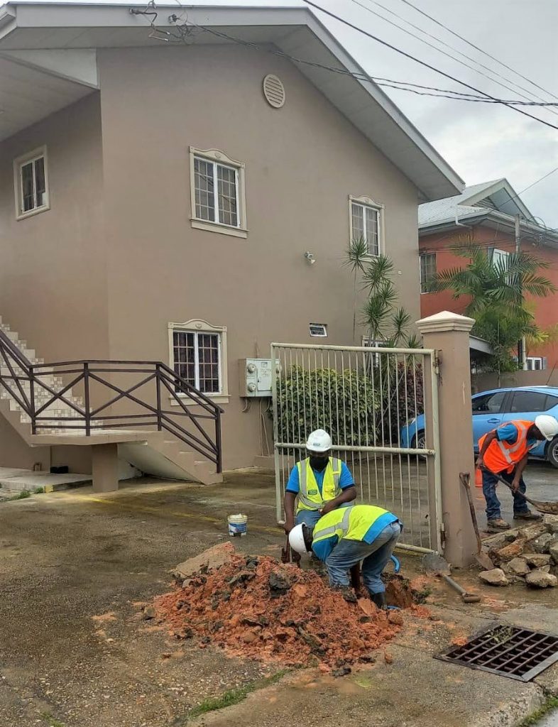 A WASA crew disconnects the water line to a house in Chaguanas on Wednesday.  Photo courtesy WASA - 