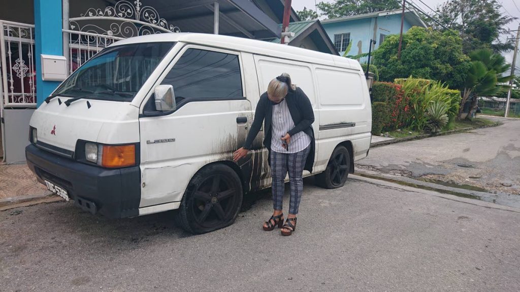 Sharmilla Jagessar shows the damage done to her husbands vehicle after lightning downed a powerline in Edinburgh 500, Chaguanas on Wednesday morning.   - 