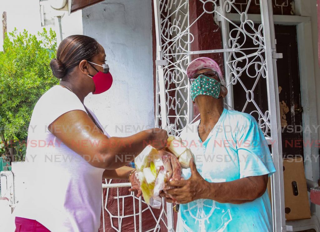At left, councillor for Belmont East Nicole Young presents the NAMDEVCO family food hamper containing two chickens and pre-packaged provisions to Ivy McClean, 82.
Photo by Roger Jacob