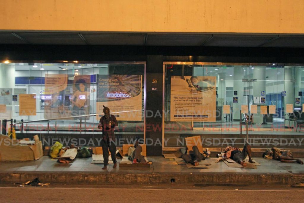The homeless bed down on the pavement in front of Royal Bank, Independence Square, Port of Spain during the curfew hours on June 19. The socially displaced are not arrested for breach of the curfew because they have no where to go. - Photo by Marvin Hamilton