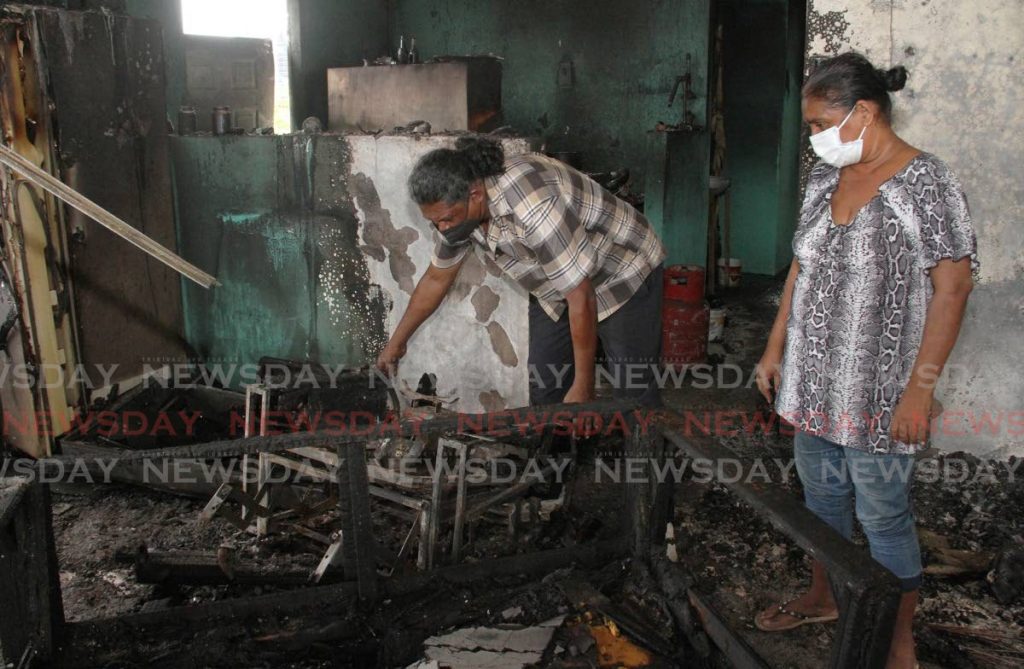 Darren and Grace Arjoon, search through the rubble at their Ethon Lane, Corinth, San Fernando homeof Darren and Grace Arjoon, after fire burnt it on Tuesday night. Photo by Angelo Marcelle - Angelo Marcelle