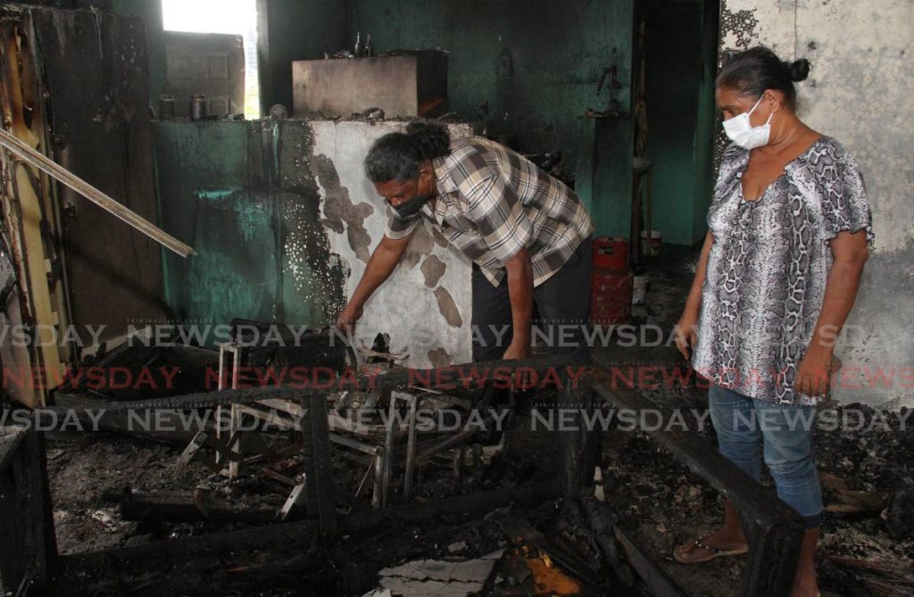 Darren and Grace Arjoon, search through the rubble at their Ethon Lane, Corinth, San Fernando homeof Darren and Grace Arjoon, after fire burnt it on Tuesday night. Photo by Angelo Marcelle 