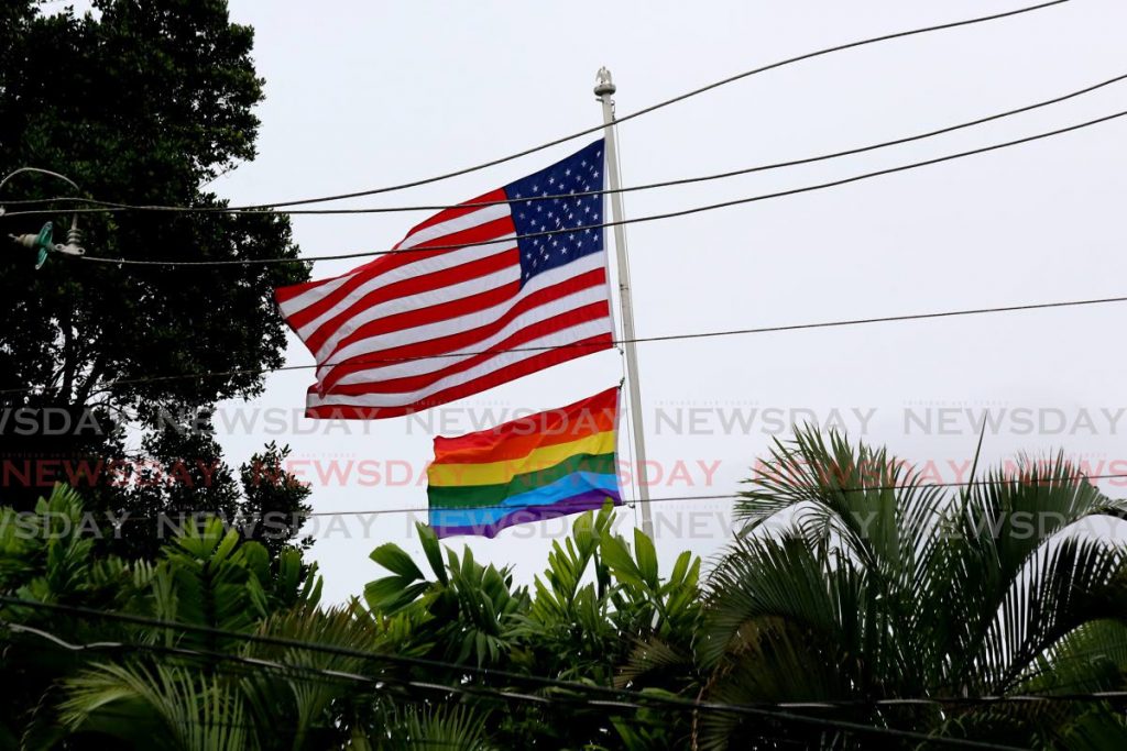 The rainbow flag flies alongside the American flag above trees at the US Embassy in Port of Spain where it was raised on Sunday in support of the LGBTQI+ community during Prime Month. - PHOTO BY SUREASH CHOLAI