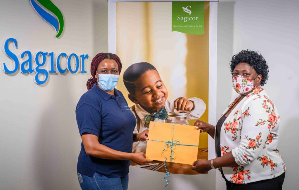 Sagicor advisor Jo-An Hislop, left, presents Esther Moore-Roberts, the Superintendent of the Moravian Church Tobago Conference with grocery vouchers to support at-risk families in the community, at Sagicor’s office in Lowlands, Tobago. - 