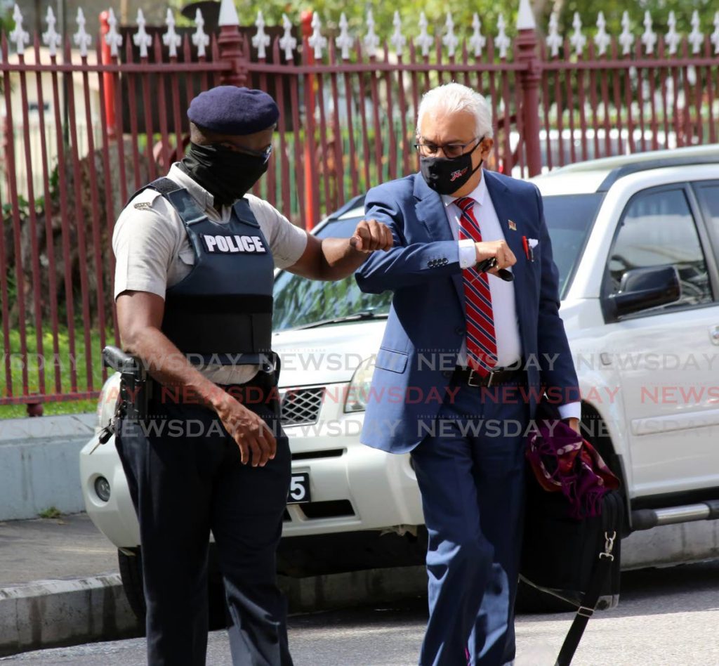 This police officer posted at the Red House receives a healthy elbow bounce from Health Minister Terrence Deyalsingh as he makes his way to the Parliament Chamber on Tuesday. - SUREASH CHOLAI