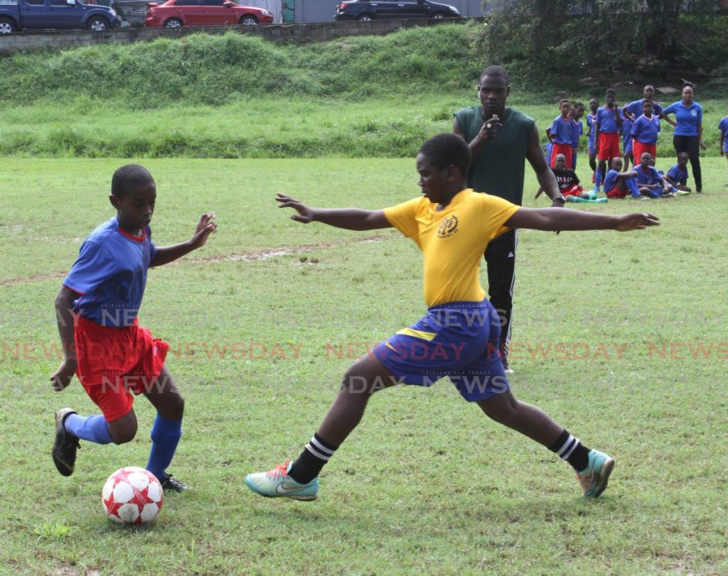 In this Nov 22,2019 file photo,A St. Dominic's Rc Primary School player, left, dribbles past a player from the Morvant Football Academy, at the TTPS North Eastern Division Morvant  Community Police 3rd annual primary school football competition, held at the Morvant Recreation Ground. On Monday, a statement issued by the FIFA announced an MoU between FIFA and Caricom which 'focuses on several key areas of collaboration, in particular the implementation of a football programme in the physical education curricula in primary schools in the Caricom region.' - Angelo Marcelle