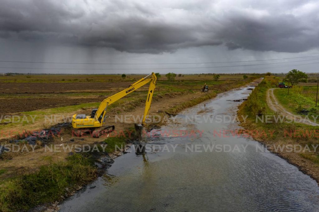Contractors working for the MOWT clean the Guaymare River off the Uriah Butler Highway, Caroni. - Jeff K. Mayers