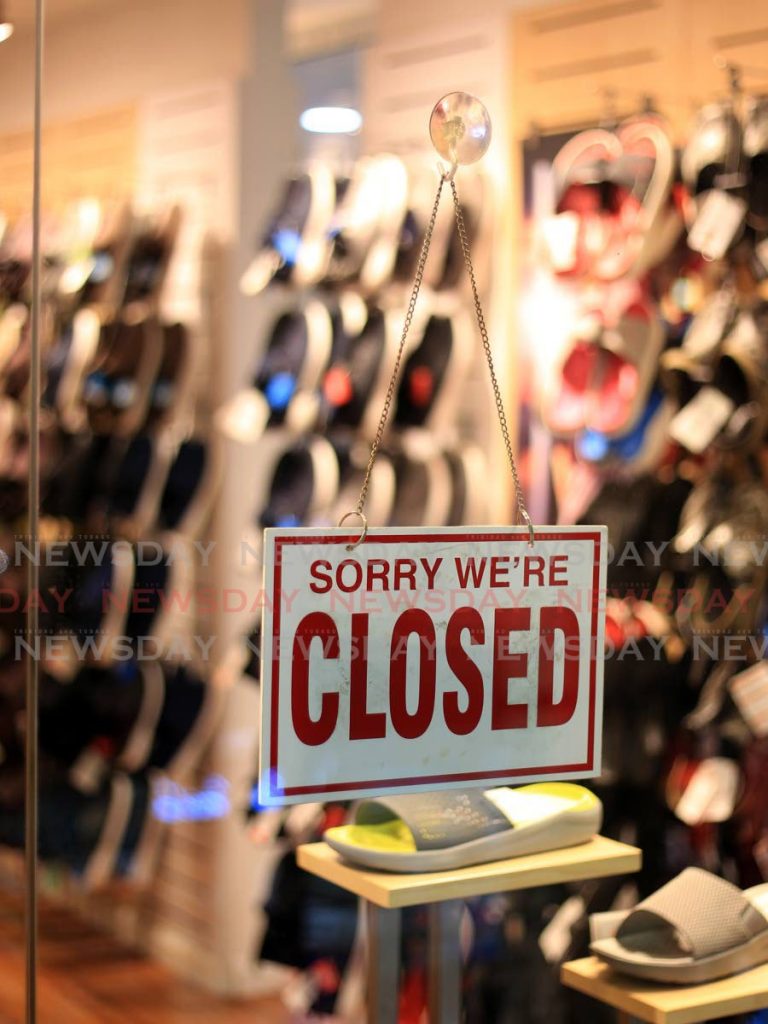 In this file photo, a closed sign hangs on the door of a store in Trincity Mall. The week leading up to Father’s Day would usually be a busy time for retailers, but owing to covid19, most stores are closed. - 
