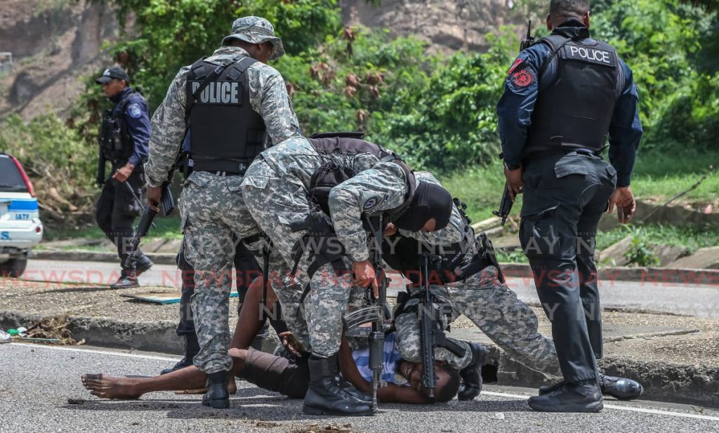 In this file photo, police detain a man during the protests in Port of Spain after three men were shot dead by cops in Second Caledonia, Morvant on June 27, 2020. - Jeff Mayers