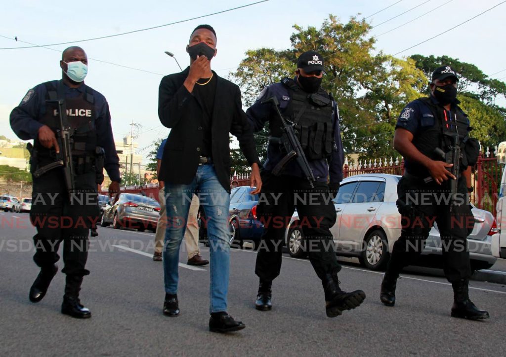 In this February 5 file photo, activist David Welch is being esscorted by police officers, after a stand-off between the police and protesters gathered demanding 'juctice for Andrea Bharatt' at Knox Street, Port of Spain. Photo by Roger Jacob