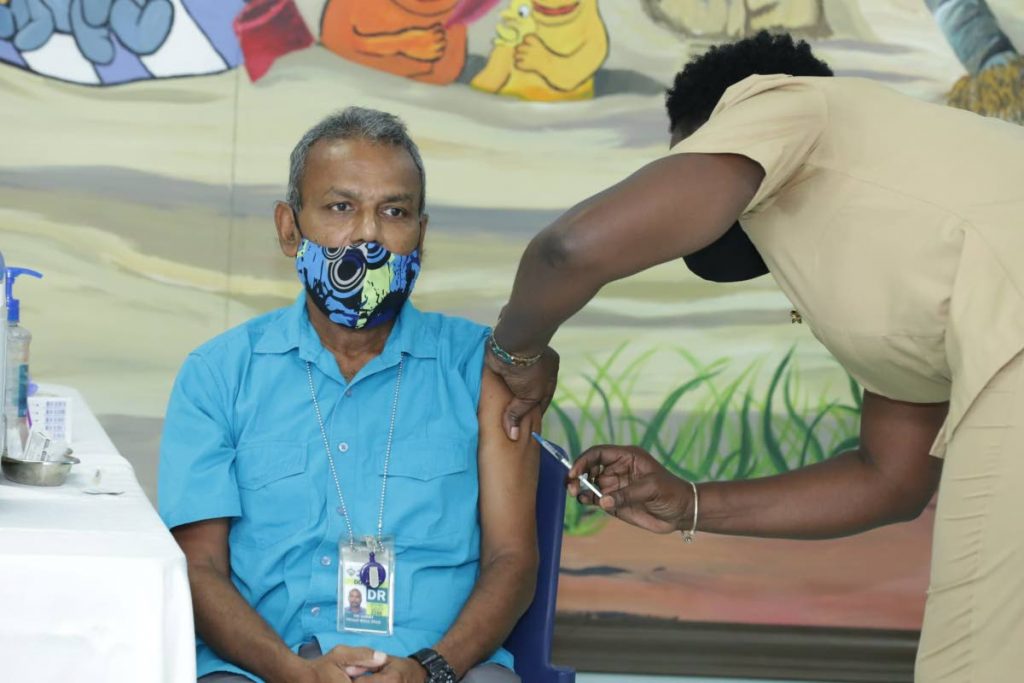 Dr Ian Sammy, head, Accident and Emergency Department, Scarborough General Hospital receives his covid19 vaccine from Beryl Samuel-Gray, District Health Visitor, earlier this year. - DIVISION OF HEALTH