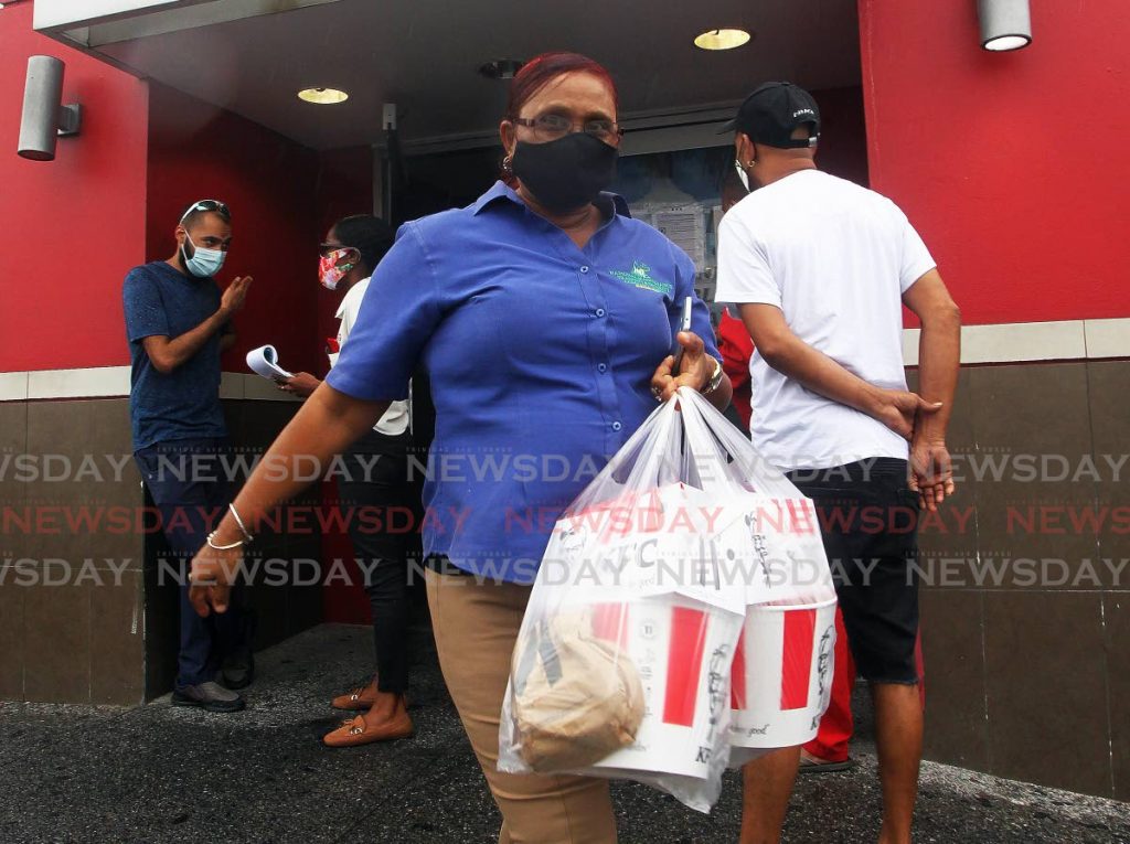 In this April 29 file photo, a customer leaves KFC Gulf View, San Fernando branch with buckets of the popular fried chicken. Restaurants will once more do takeaway and delivery services from July 19.
 - File photo
