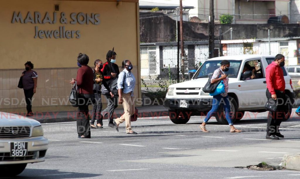 Pedestrians head to City Gate across South Quay in Port of Spain. - File photo