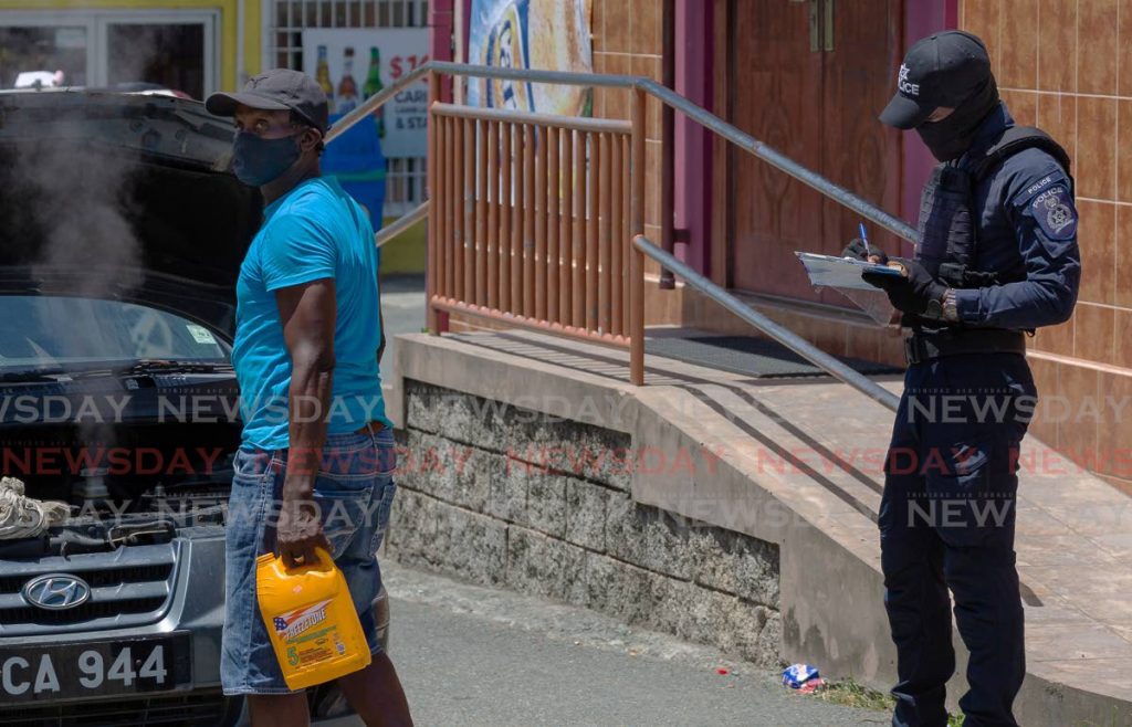 FLASHBACK: An officer from the Covid19 Enforcement Unit issues a ticket to a man for not wearing a mask in Goodwood, Tobago back in May. The Judiciary announced that fines for such offences including not wearing a mask in public can now be paid online. FILE PHOTO - 