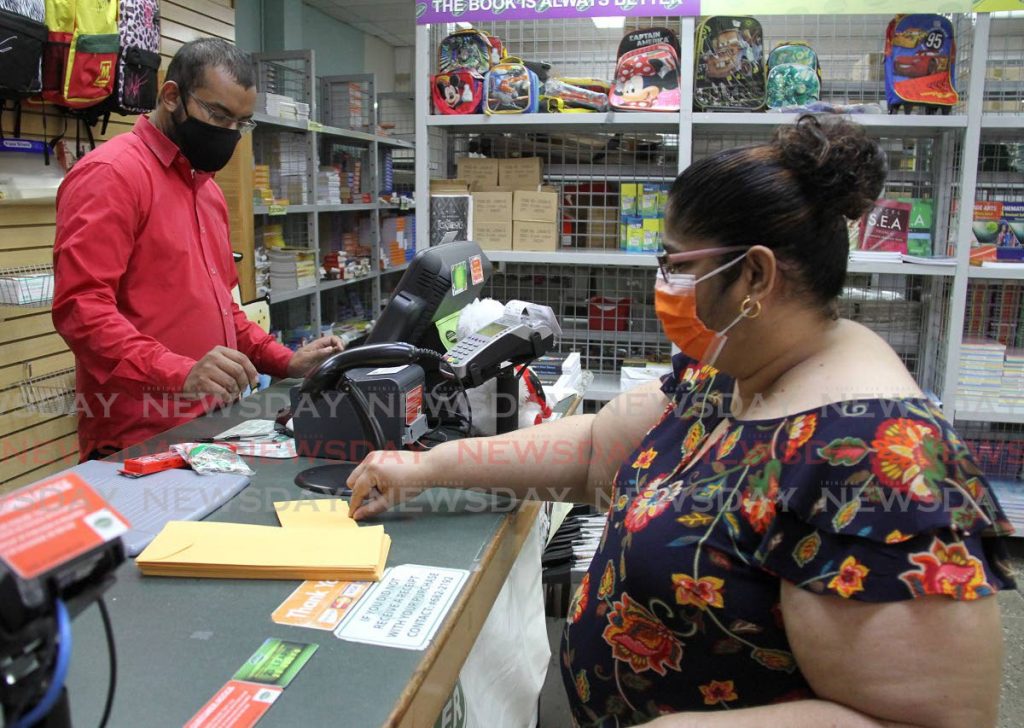In this June 14 file photo, Arlene Sanichar completes a purchase at Nigel R Khan Bookselllers in Marabella when bookstores re-opened.  Photo by Angelo Marcelle