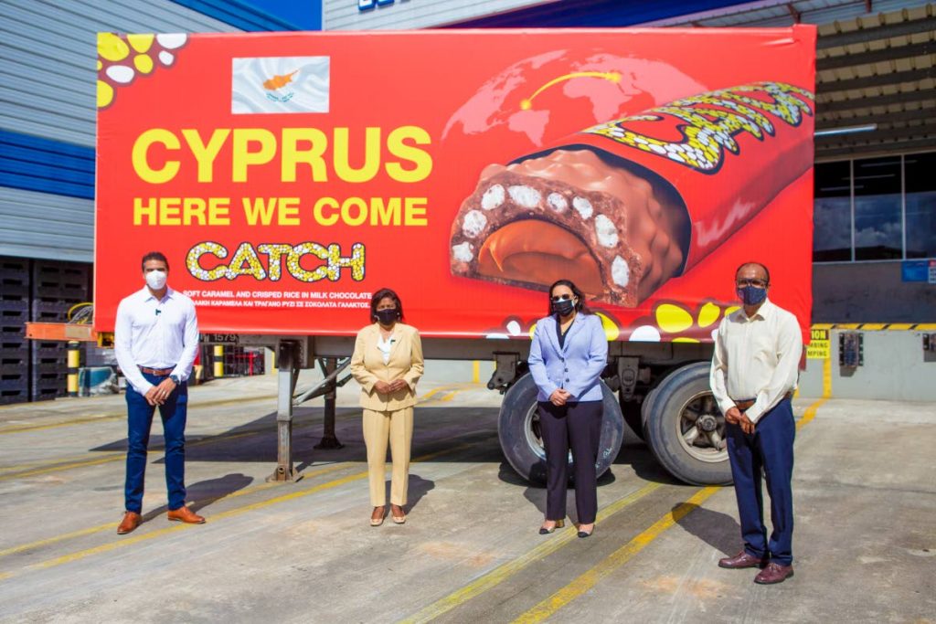 ABIL Group CEO/deputy chairman Nicholas Lok Jack, Trade and Industry Minister Paula Gopee-Scoon, TTMA president Tricia Coosal and TTMA CEO Dr Mahindra Ramdeen stand in front a billboard announcing that Catch chocolate bar will be sold in Cyprus. - 