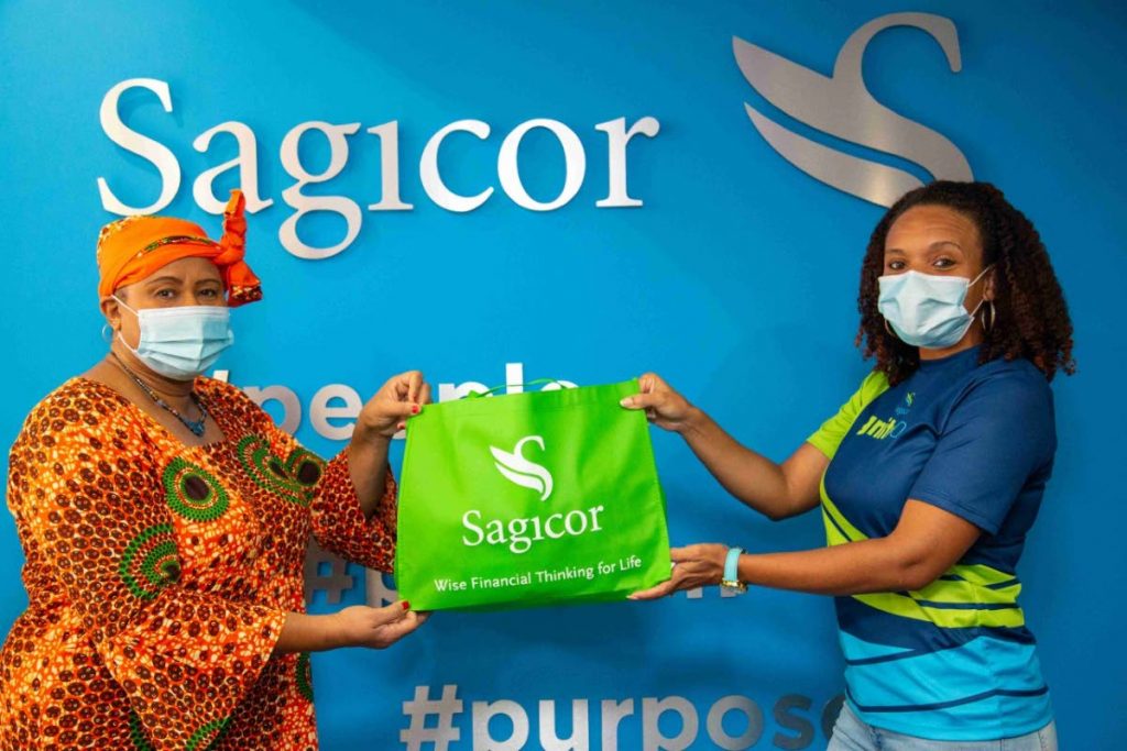  Sagicor Life Inc Employee of the Year 2020 Talia Simpson-Grant, right, hands over SEA kits to the principal of Laventille Girls Government Primary School, Patricia Thorington for her Standard five students, at Sagicor’s head office in Port of Spain. - 