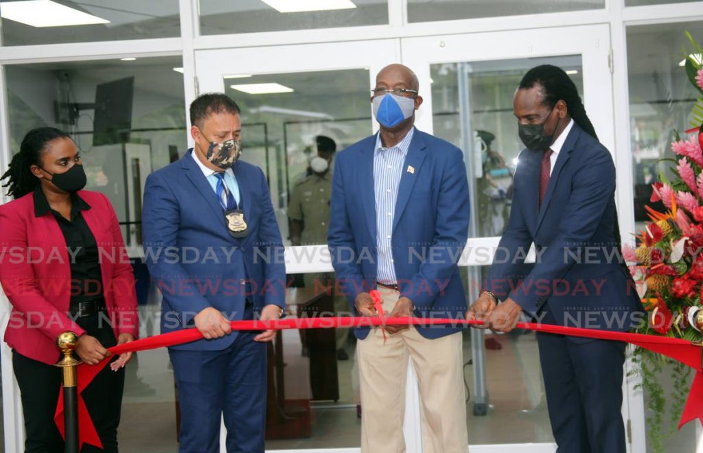 The Prime Minister, second from right, cuts the ribbon at the opening of the new Carenage Police Station, Western Main Road, Carenage on Thursday. Also pictured are, from left, Udecott CEO Tamica Charles-Phillips, Police Commissioner Gary Griffith and Minister of National Security Fitzgerald Hinds. - Photo by Sureash Cholai